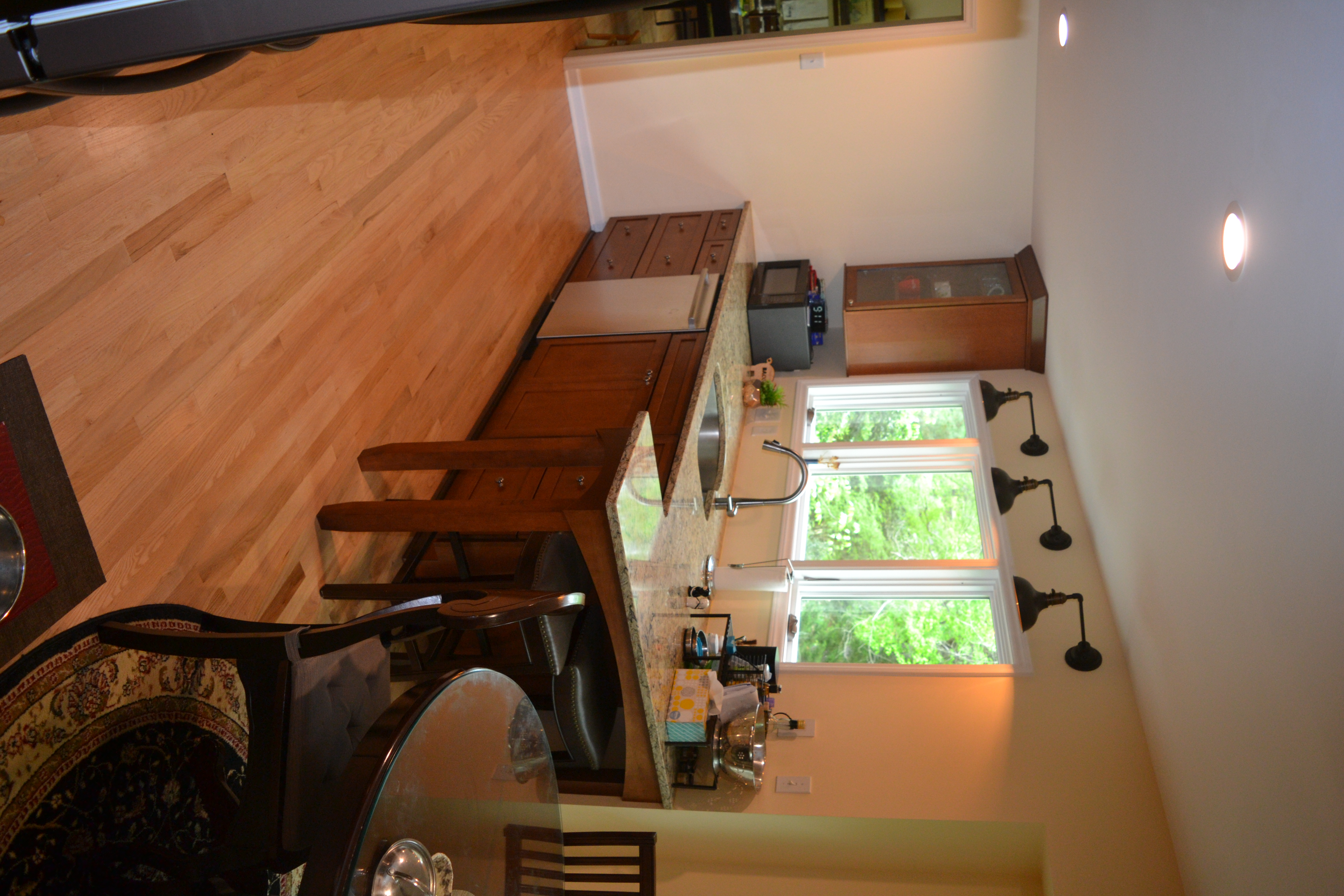 A photograph of the inside of a modern kitchen, showing a table and a window.