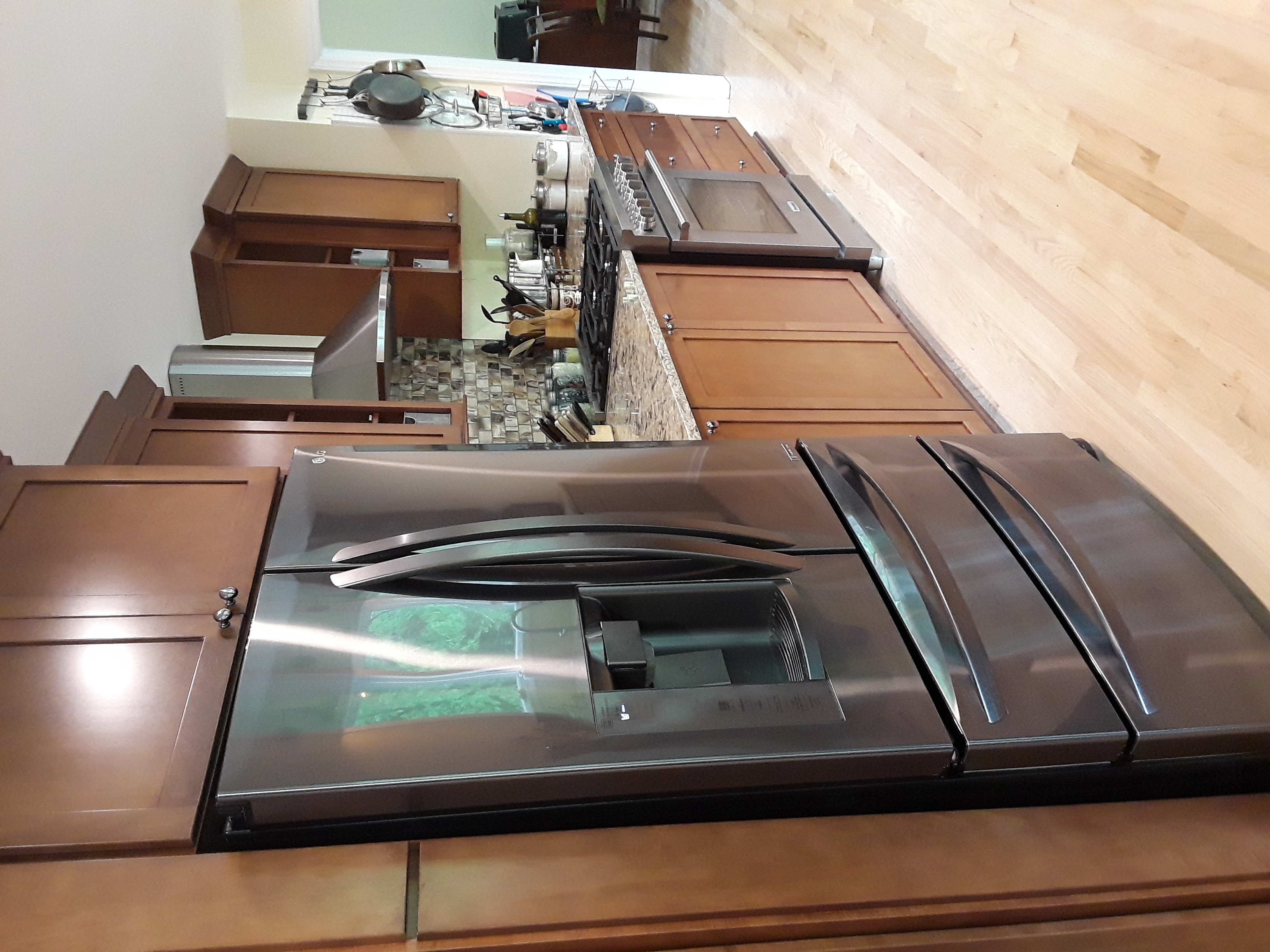 A photograph of the inside of a modern kitchen, showing a fridge, stove and countertop.